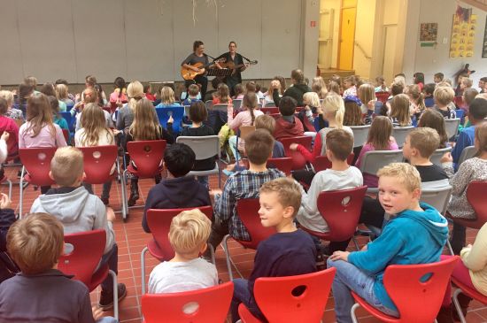 Kinder singen zu zwei Gitarren